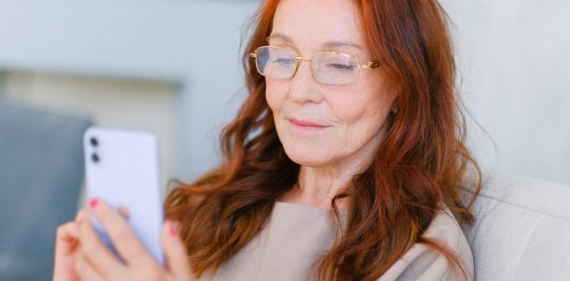 Woman wearing glasses while looking at her smartphone