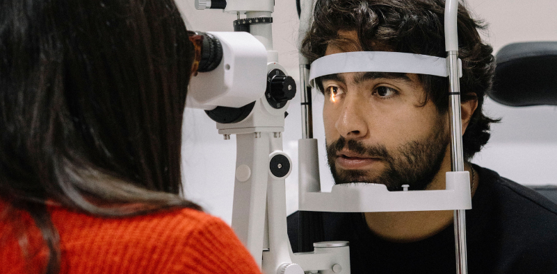 Man having his eyes examined using a slit lamp