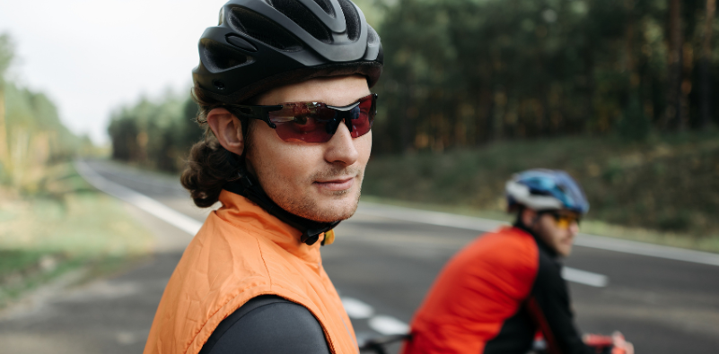 Cyclists wearing helmets and sports sunglasses on a road