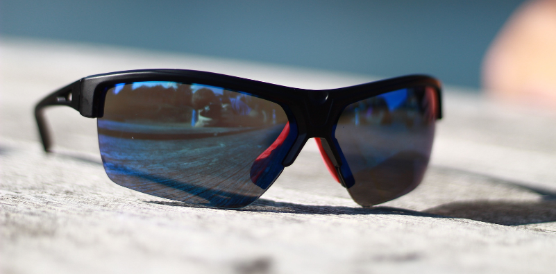 Black wraparound sports sunglasses with blue-tinted lenses.