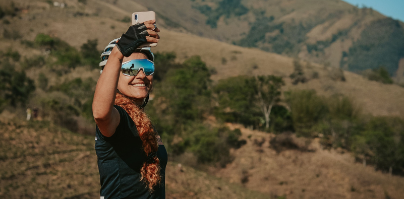 Cyclist wearing mirrored sports sunglasses and taking a selfie
